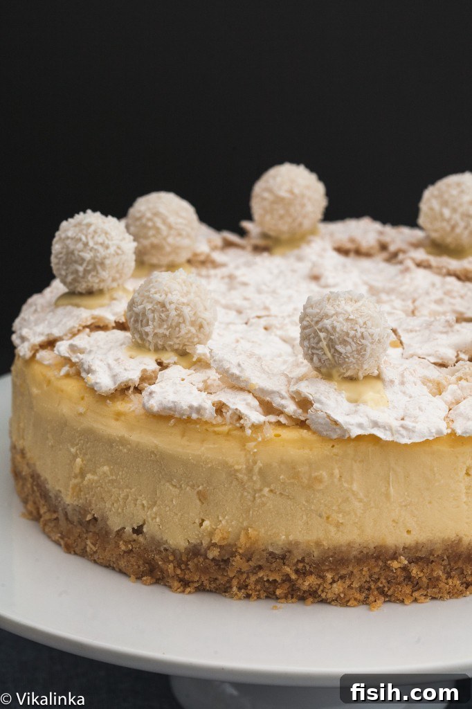 Angled view of the cheesecake on a stand, highlighting its smooth texture and decorative top.