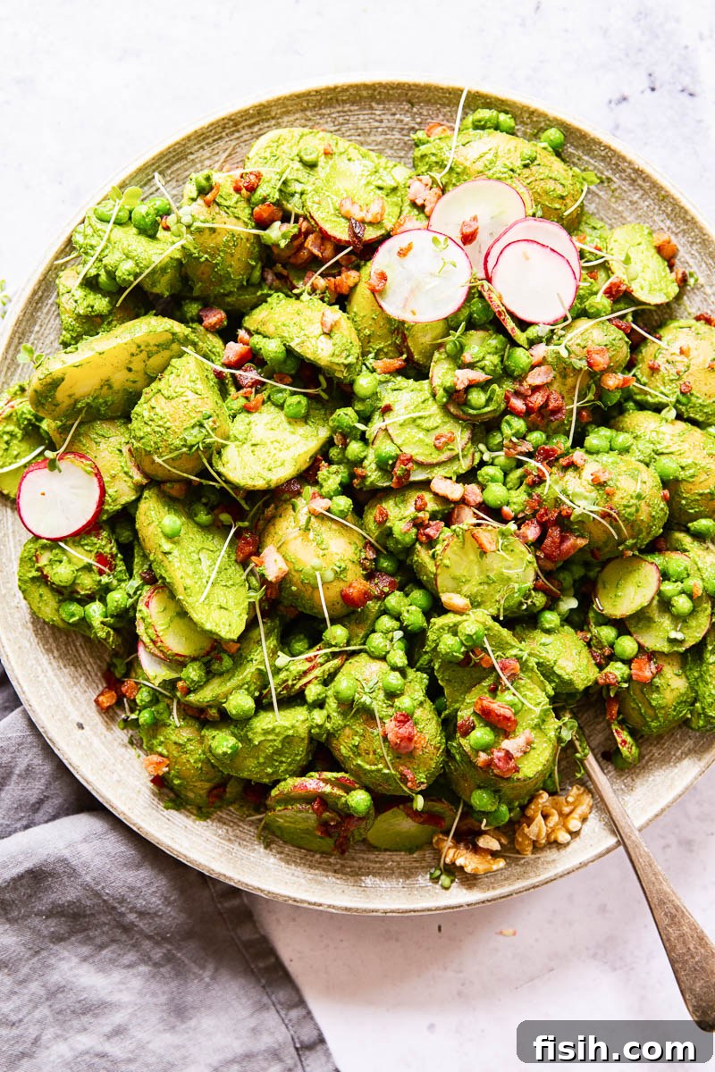 A generous serving of Pesto Potato Salad artfully arranged on a large platter, ready to be enjoyed at a gathering.