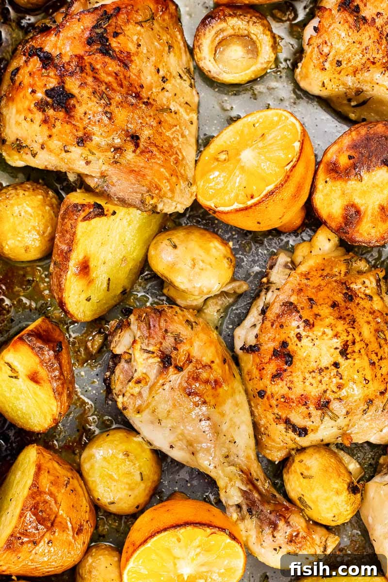 Close-up of crispy roasted chicken and tender potatoes nestled amongst mushrooms, glistening with lemon and herb marinade.