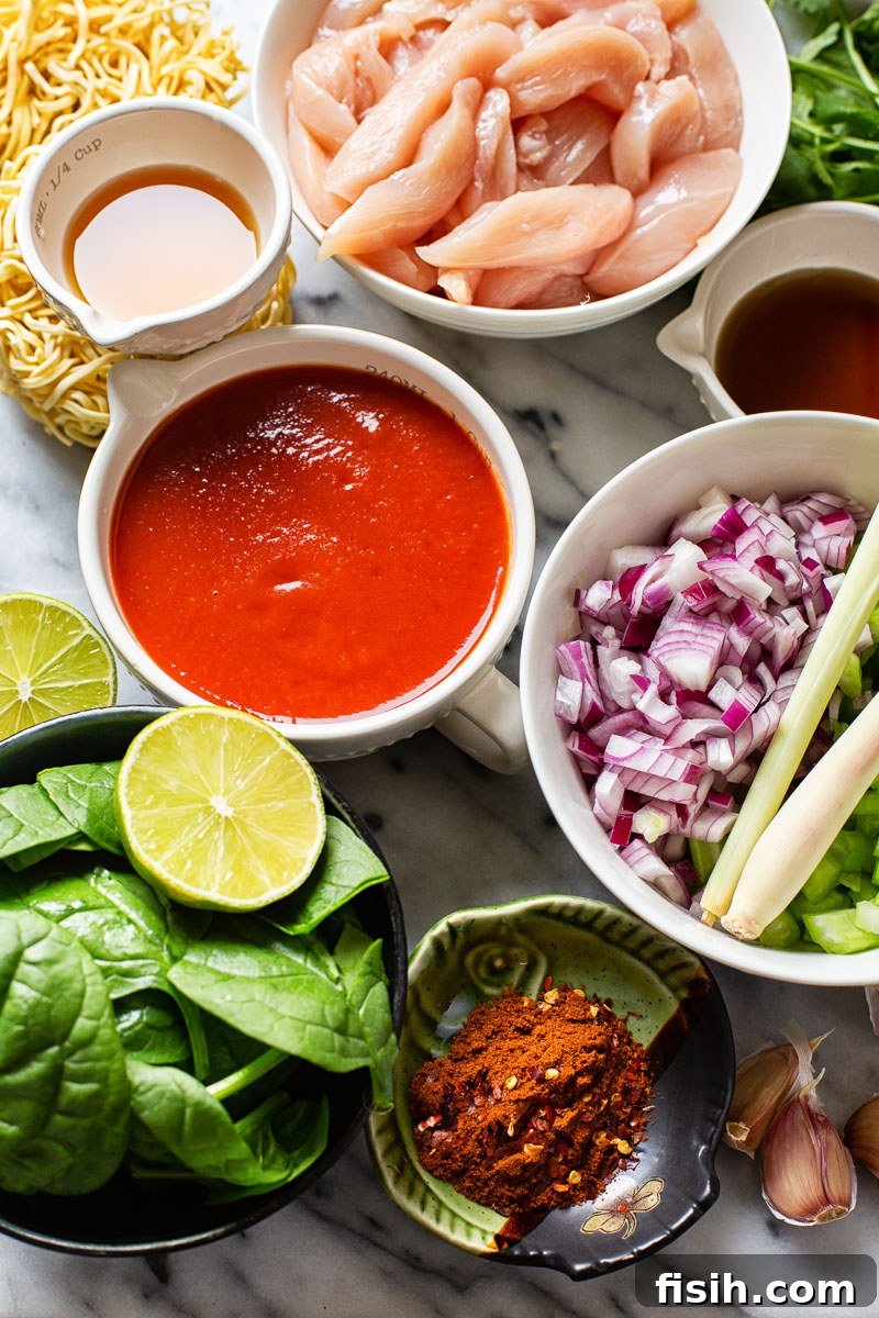 Authentic Thai Noodle Soup Made Easy 4 A selection of fresh ingredients for Thai Chicken Noodle Soup, including lemongrass, chili, and cilantro.