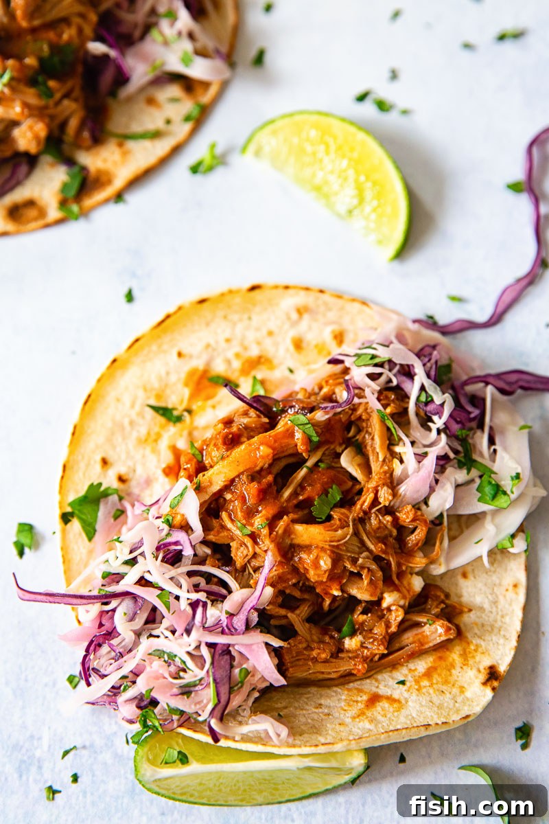 Melt-in-Your-Mouth Pulled Pork Tacos with Bright Cilantro Lime Slaw 5 soft taco topped with pulled pork and slaw