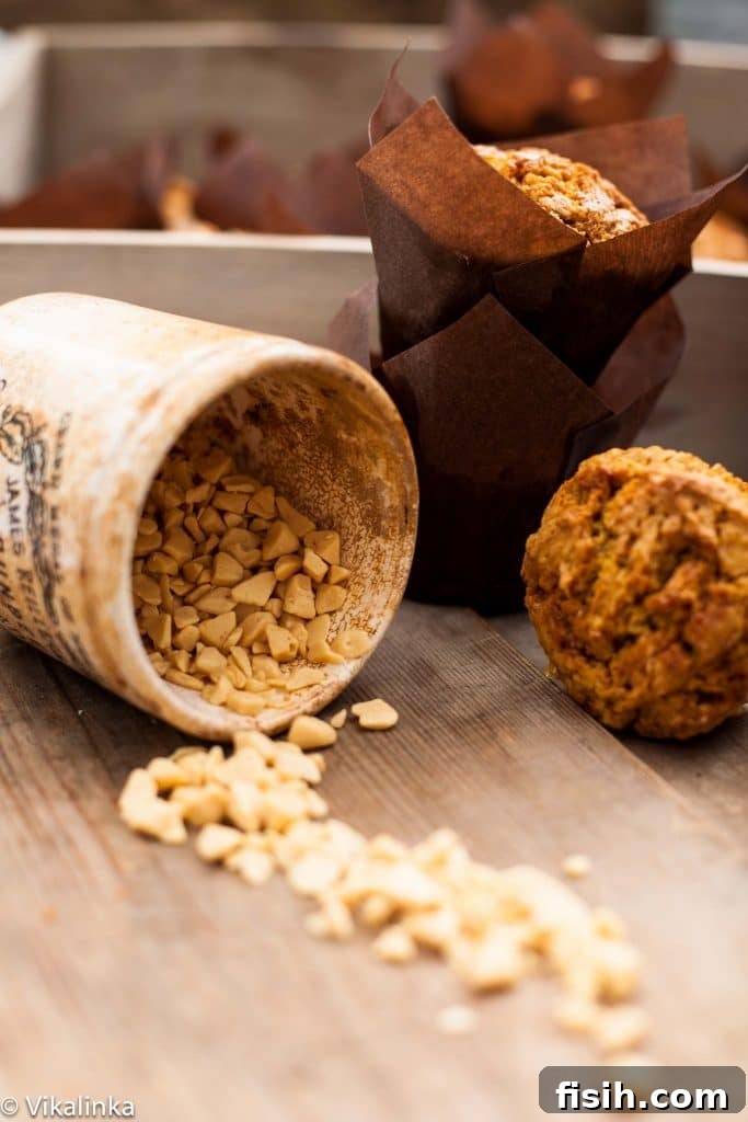 Golden Pumpkin Muffins with Toffee Honeycomb Crunch 5 A canister gracefully spilling golden pieces of toffee into the foreground, with warm baked goods blurred in the background, hinting at their delicious use.