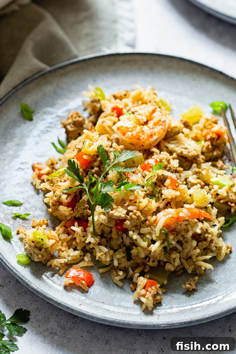 A plate of Cajun Dirty Rice with Shrimp, garnished with fresh herbs