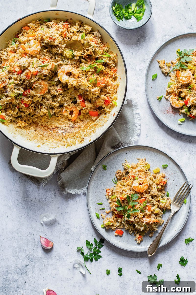 Top down shot showing a pan of Cajun Dirty Rice and two individual servings on plates