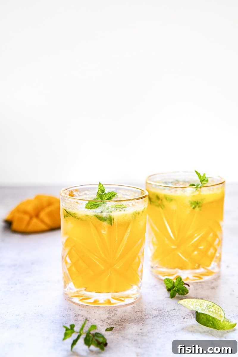 Close-up of a refreshing Mango Mojito with visible mint leaves and ice.