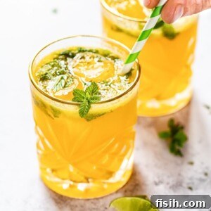 Mango Mojito cocktail in a glass with mint and lime.