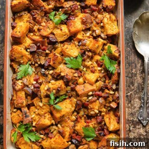 Top down shot of chorizo stuffing in a baking dish topped with fresh parsley