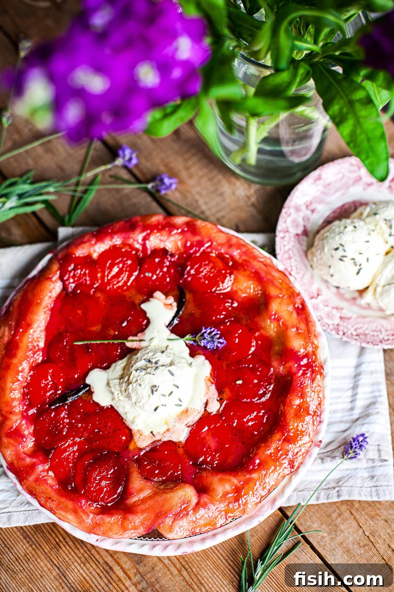 tarte tatin on wooden table, purple flower in vase
