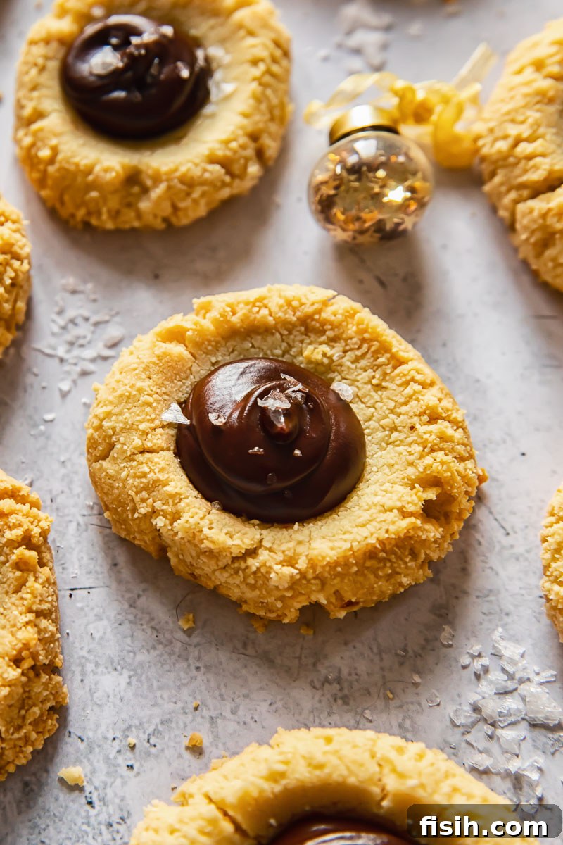 Close-up of freshly baked almond thumbprint cookies, showcasing their inviting indentations.