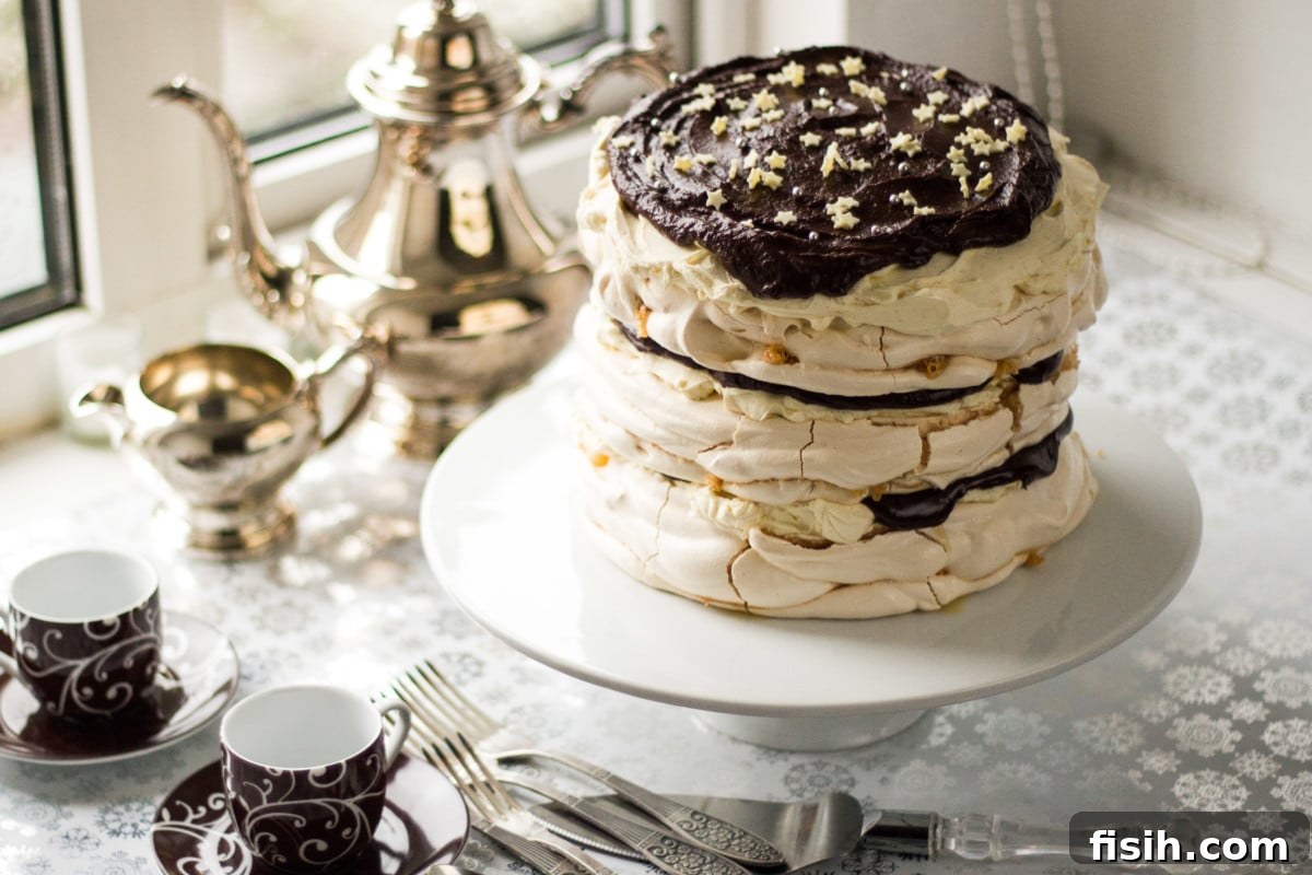 Top down view of a beautifully adorned meringue mascarpone cake on a pristine white cake stand, invitingly decorated with festive sprinkles.