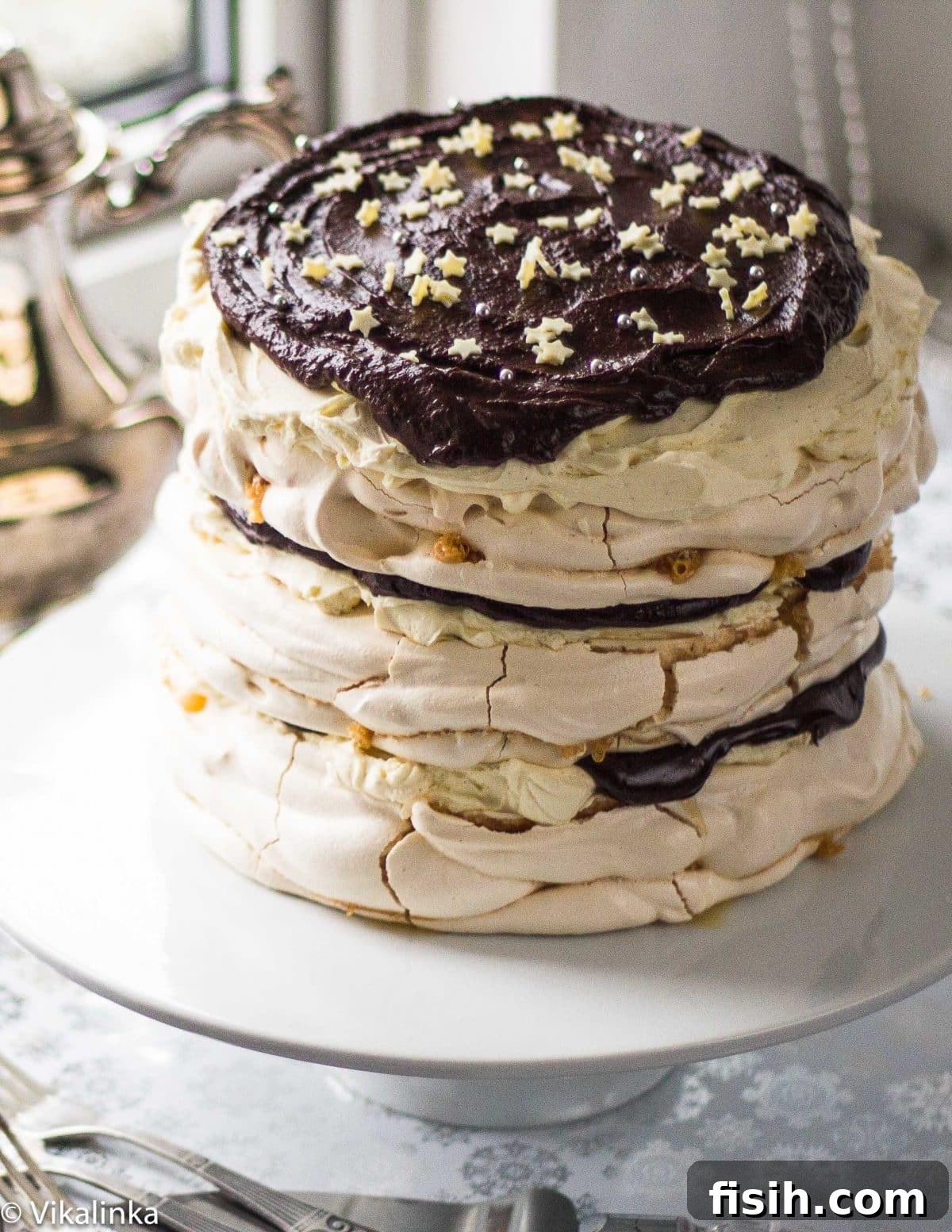 Close-up of a generous slice removed from a Meringue Mascarpone Cake, beautifully revealing its distinct layers of crispy meringue, creamy filling, and rich chocolate, ready for serving.