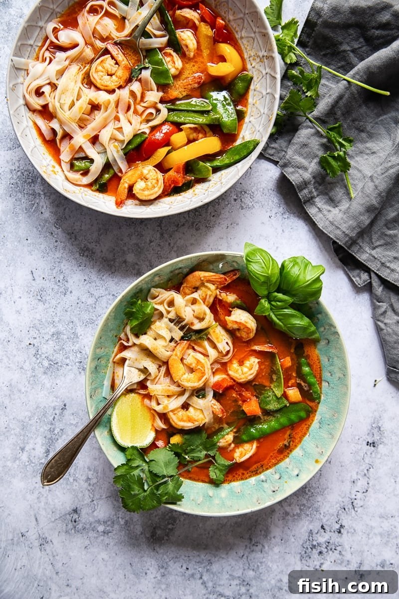 A close-up of Thai Red Curry with Prawns and Snow Peas, highlighting the vibrant colors and fresh ingredients within the blue bowl.
