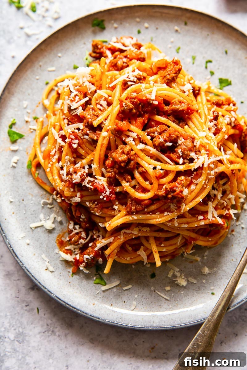 Classic Spaghetti Bolognese 3 Close-up of spaghetti topped with a rich, red meat sauce, showcasing the hearty texture and vibrant colors of the dish.