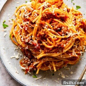 Close-up of spaghetti topped with a rich, red meat sauce