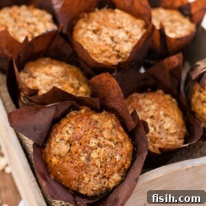 A full bread box of healthy carrot oatmeal muffins, tempting and ready for serving.