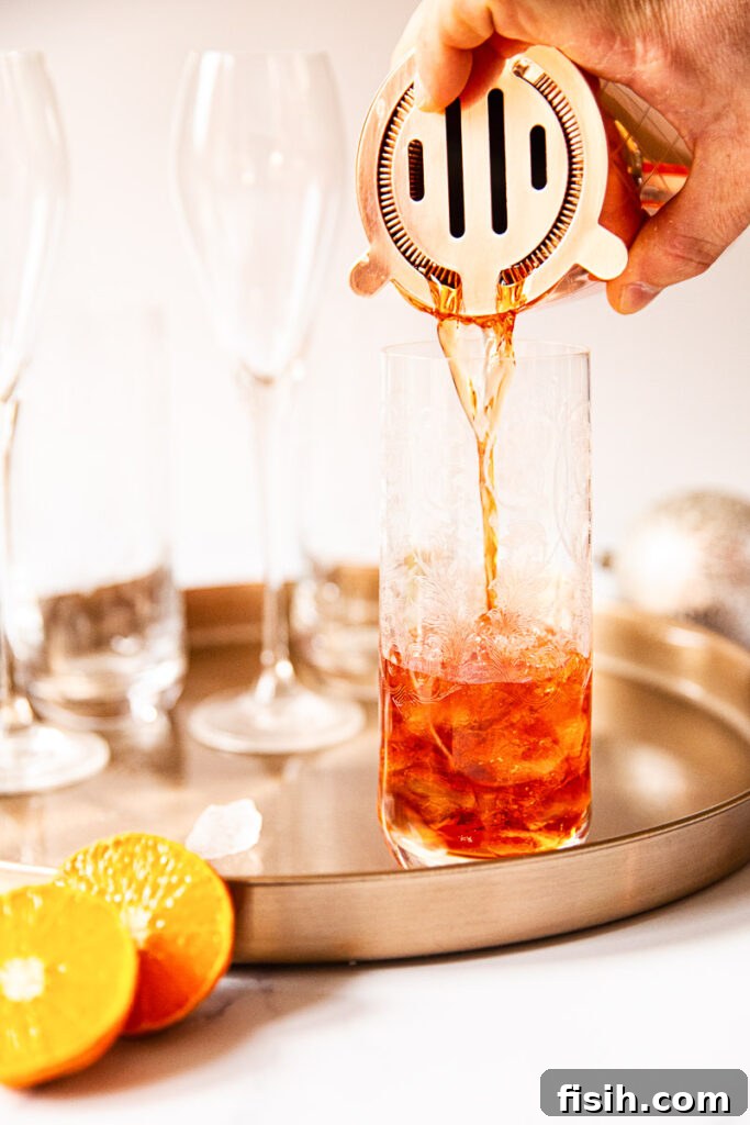 Negroni pouring from shaker into a glass