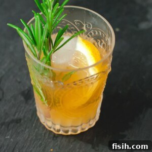 A vibrant Cognac Sour cocktail garnished with a lemon slice and rosemary.