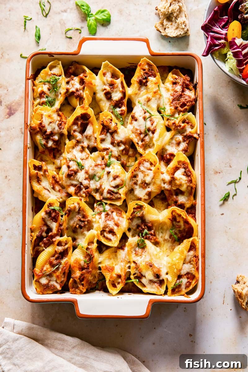 Quick Pesto Beef and Tomato Shells 3 Overhead view of a baked pasta dish with melted cheese and red sauce