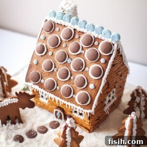 Finished gingerbread log cabin with snow and festive decorations, a perfect holiday treat
