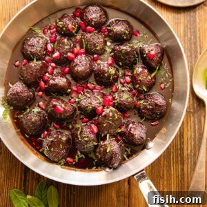 Top down image of sweet and sour meatballs in pomegranate sauce on a wooden background