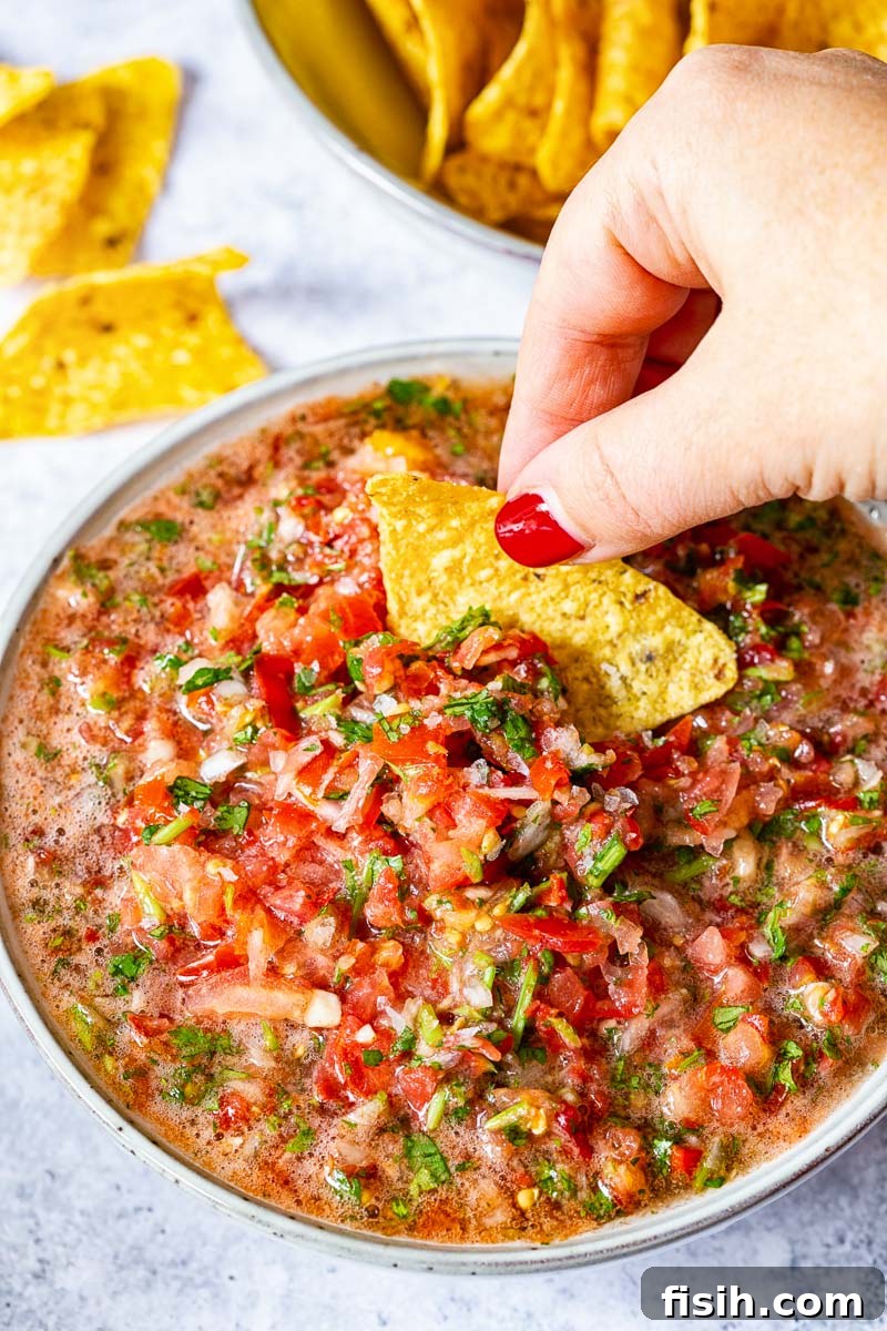 A large bowl of salsa fresca served with tortilla chips, ready for dipping
