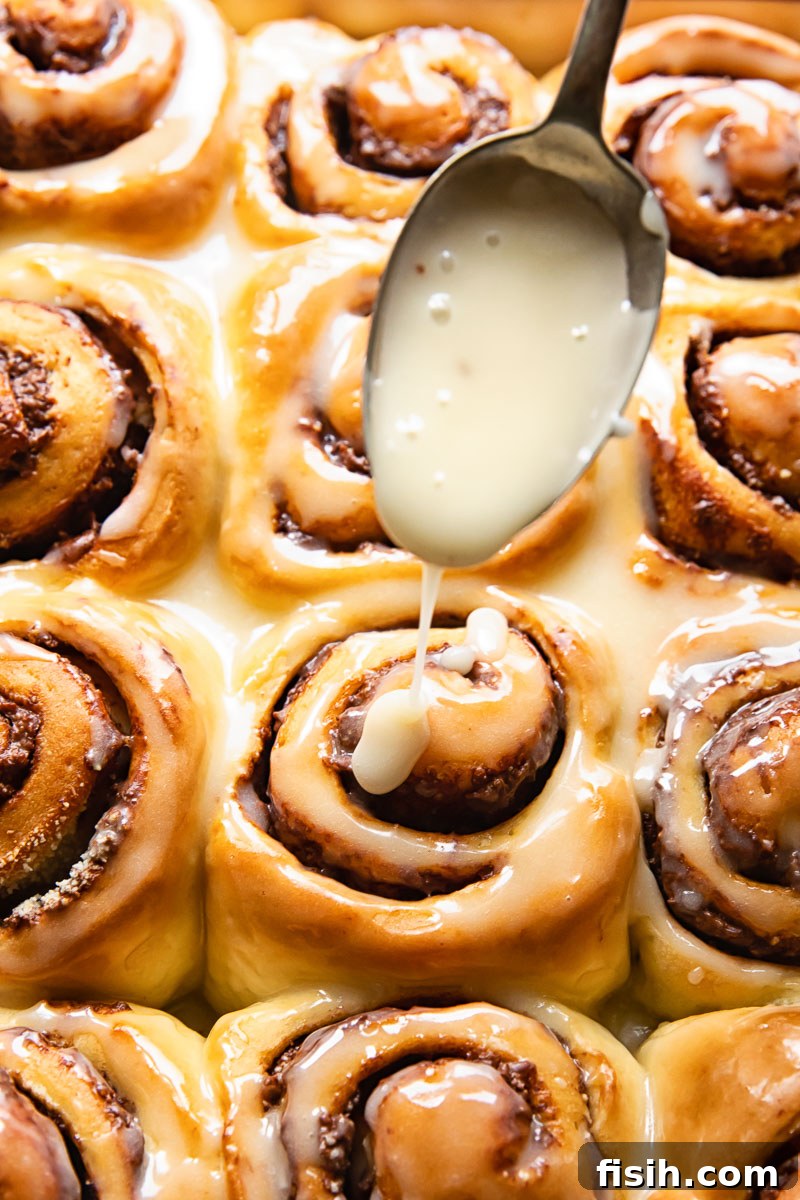 Chocolate Nutella rolls being glazed with vanilla sugar icing