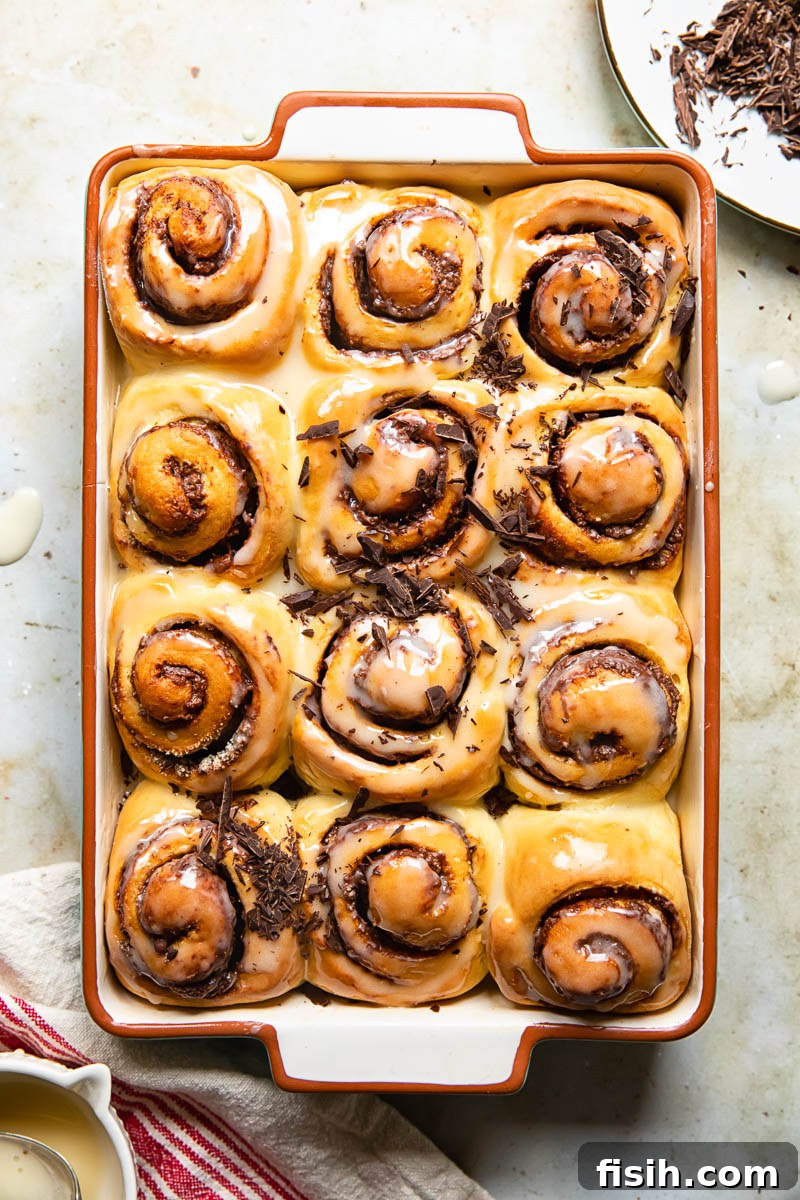 Top-down view of glazed chocolate Nutella rolls topped with chopped chocolate