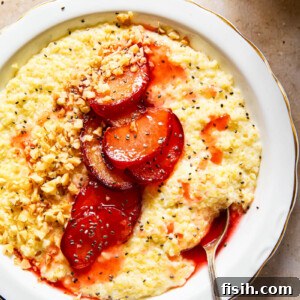 millet porridge in white bowl topped with cooked plums, walnut and chia seeds