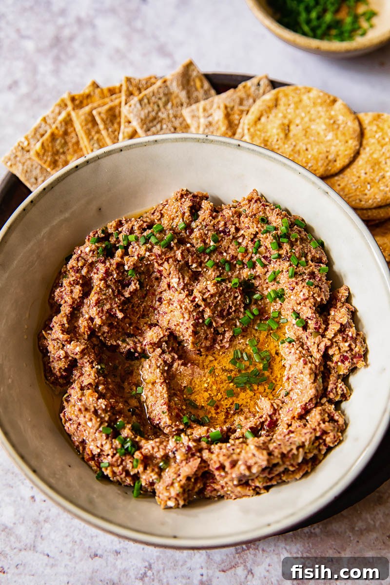 Creamy Feta Olive Tapenade 2 top down view of olive tapenade with crackers, showcasing a vibrant, chunky texture perfect for dipping