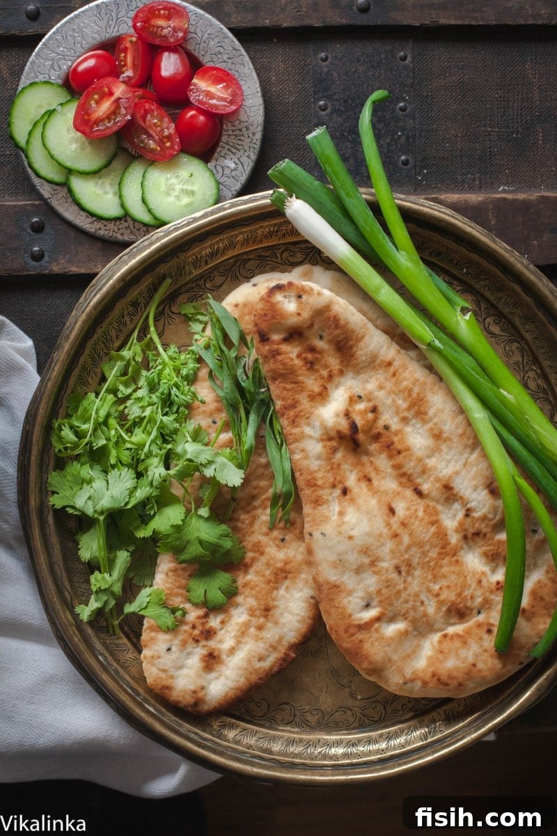 Top down shot of naan and greens on plate