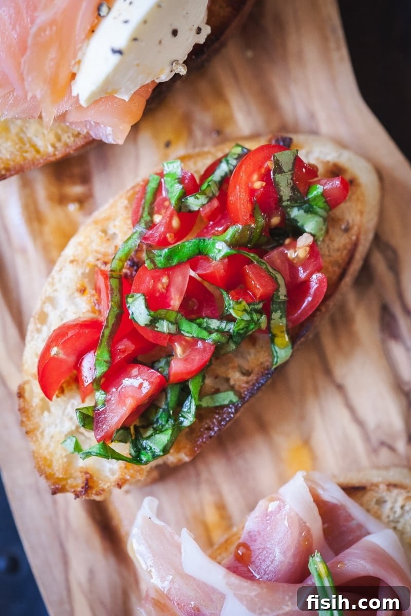 Crostini Quartet: Four Party-Ready Bites 3 Close-up of a crostini topped with fresh cherry tomatoes, vibrant green basil, and a sprinkle of salt.
