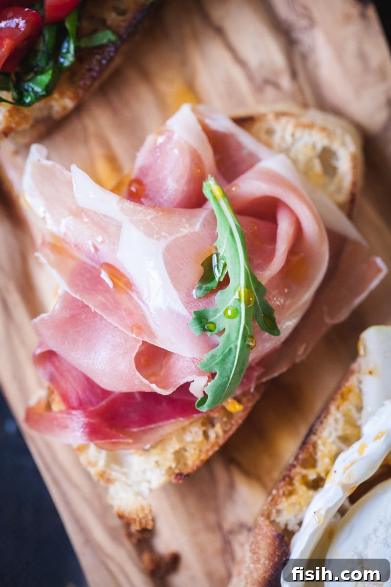 Crostini Quartet: Four Party-Ready Bites 6 A perfectly assembled crostini topped with thinly sliced prosciutto, draped elegantly over the toasted bread.