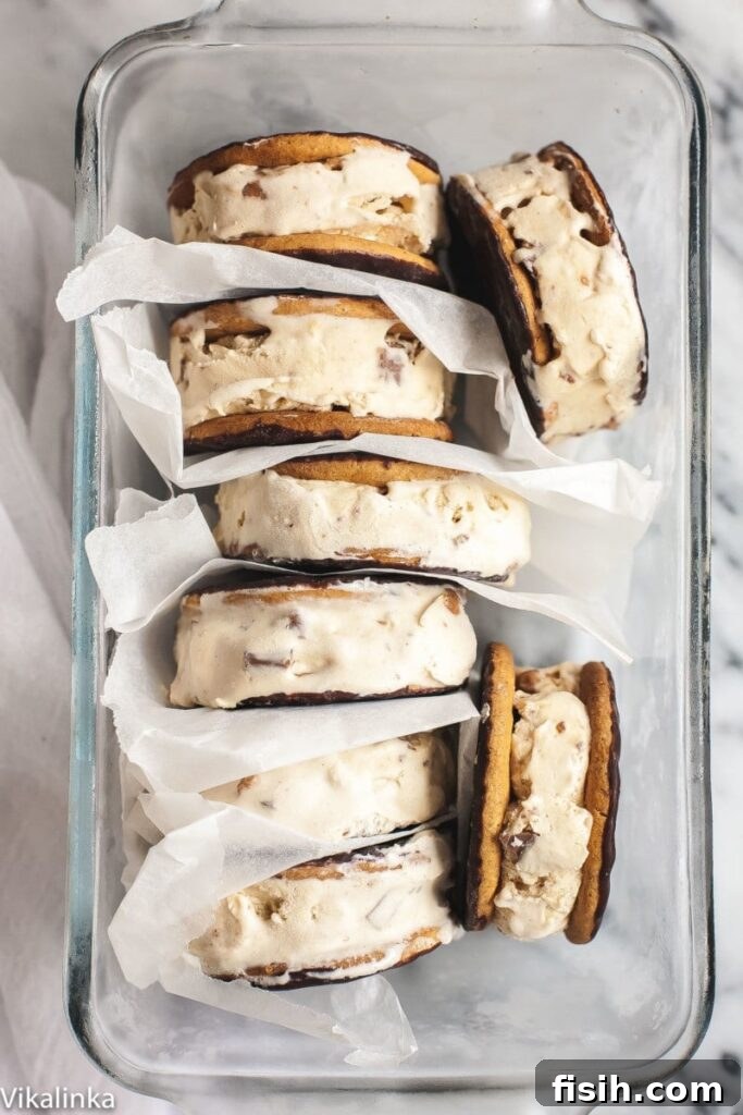 Ice cream sandwiches inside a clear dish separated by parchment paper