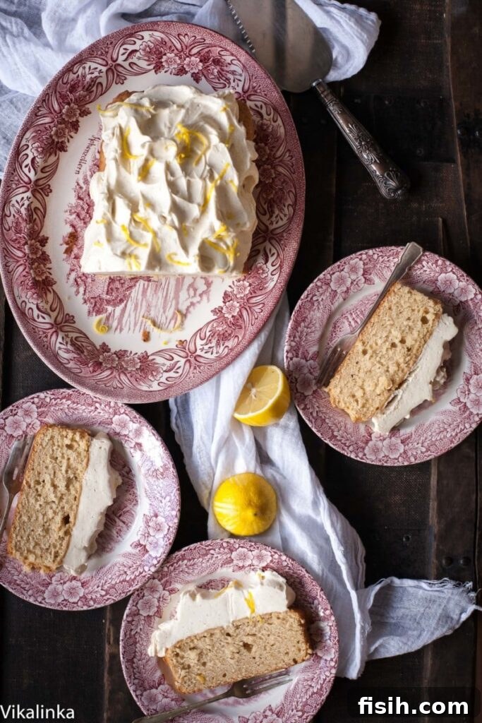 Zesty Lemon Ricotta Cloud Cake with Tangy Cream Cheese Frosting 4 An overhead view of a perfectly baked lemon ricotta loaf cake, generously topped with a mound of creamy white cream cheese frosting and sprinkled with bright yellow lemon zest for a vibrant finish.