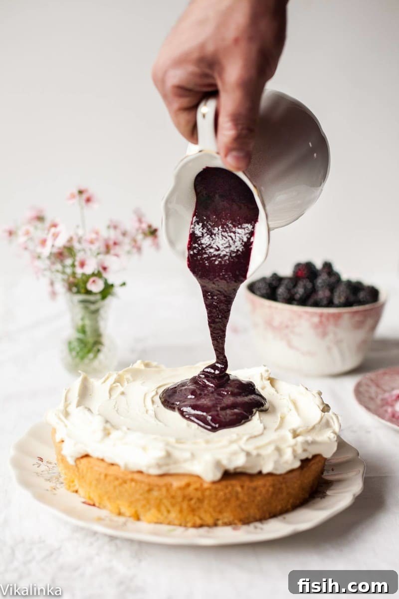 A full Classic Victoria Sponge Cake with Blackberry compote presented beautifully on a cake stand