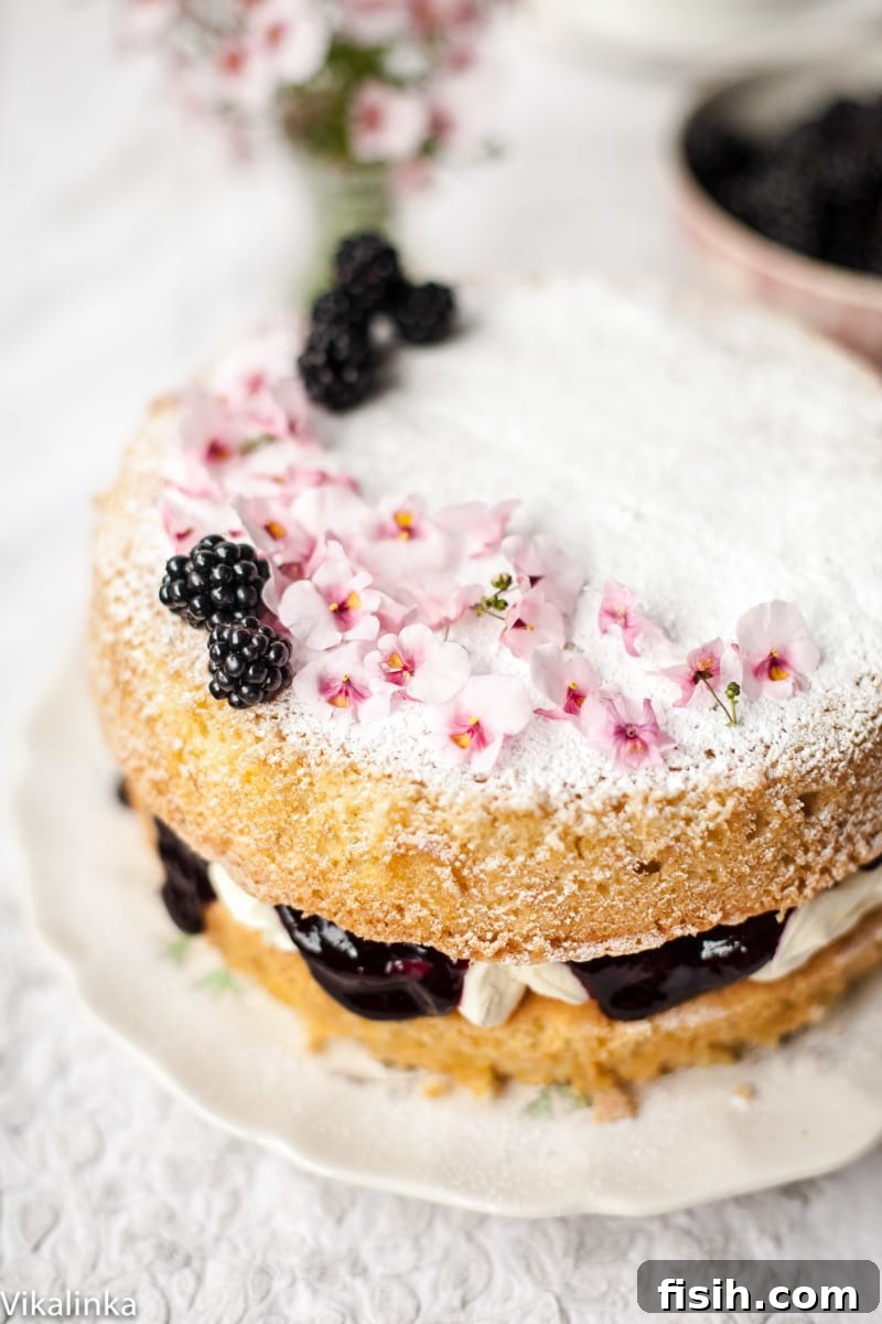 Top view of a Classic Victoria Sponge Cake with a generous dusting of icing sugar