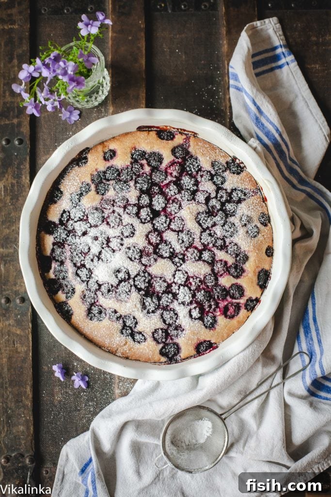 An overhead view of the freshly baked Wild Blackberry Tea Cake, its golden-brown top dotted with vibrant, jammy blackberries.