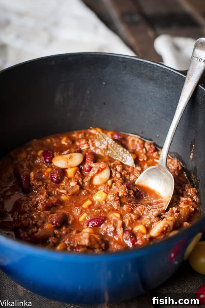 Ultimate Texas Chili 5 A large pot of rich chili with a serving spoon resting inside, ready to be dished out.