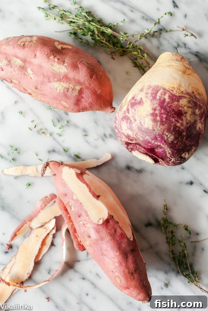 A vibrant bowl of fluffy sweet potato and swede mash, ready to be served, on a rustic wooden surface.