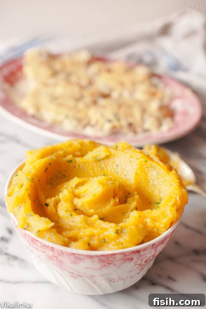 A serving of creamy sweet potato and swede mash, garnished with fresh herbs, ready to be enjoyed.