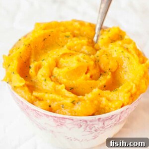 Sweet potato and swede mash in a bowl on a white background
