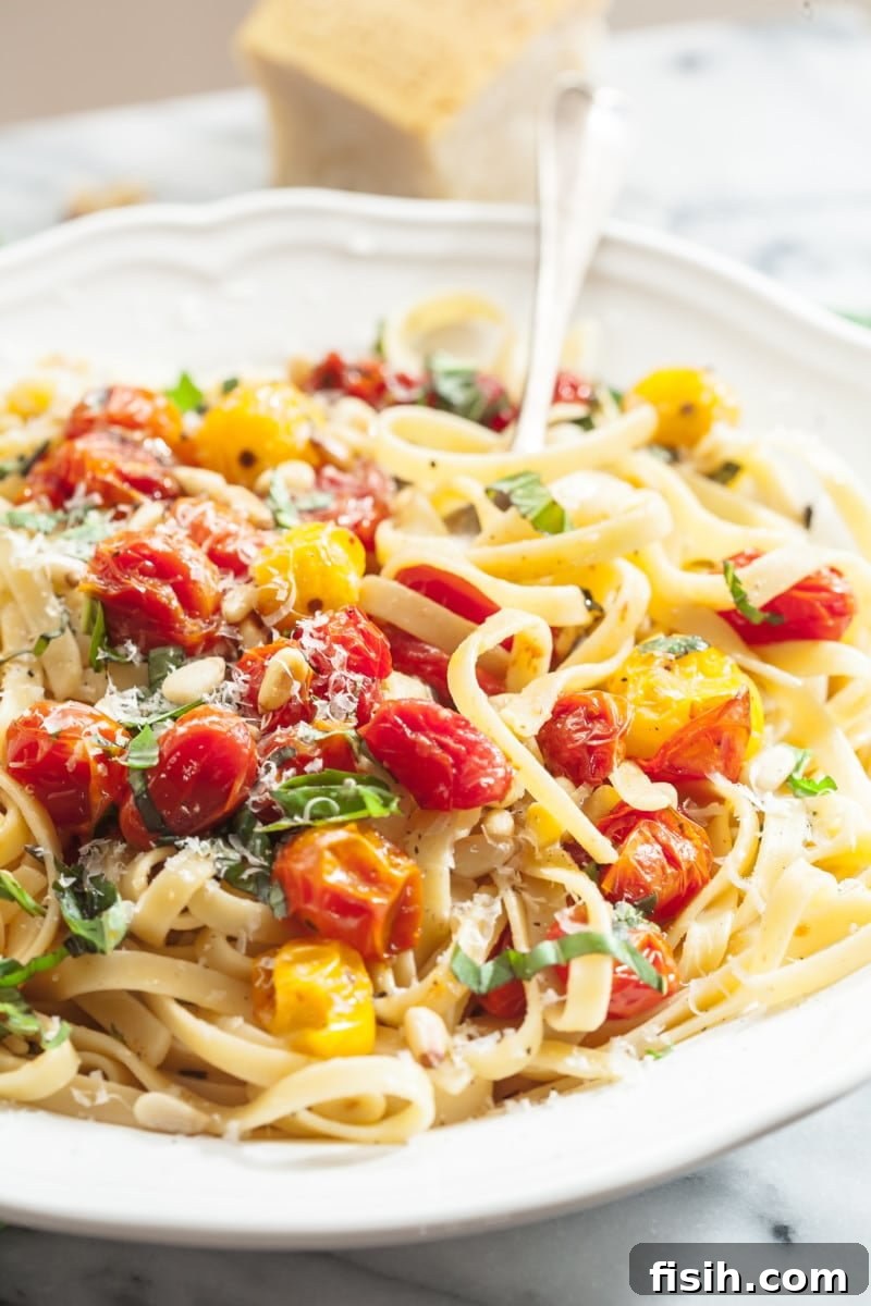 Close-up of cherry tomato and basil fettuccine in a bowl, ready to be served.