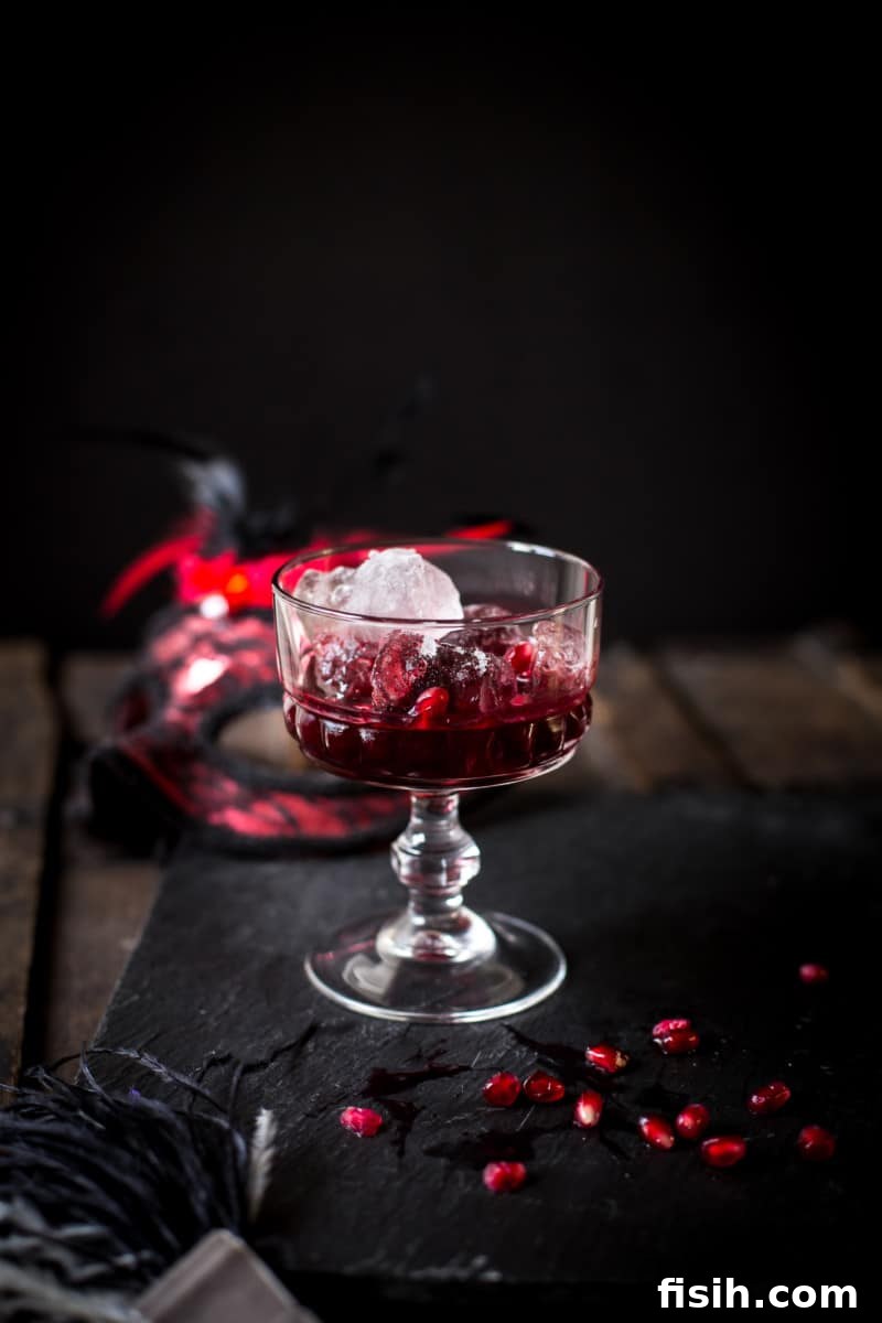 A close-up of a sparkling berry crush cocktail, brimming with crushed seasonal berries and vibrant pomegranate seeds.