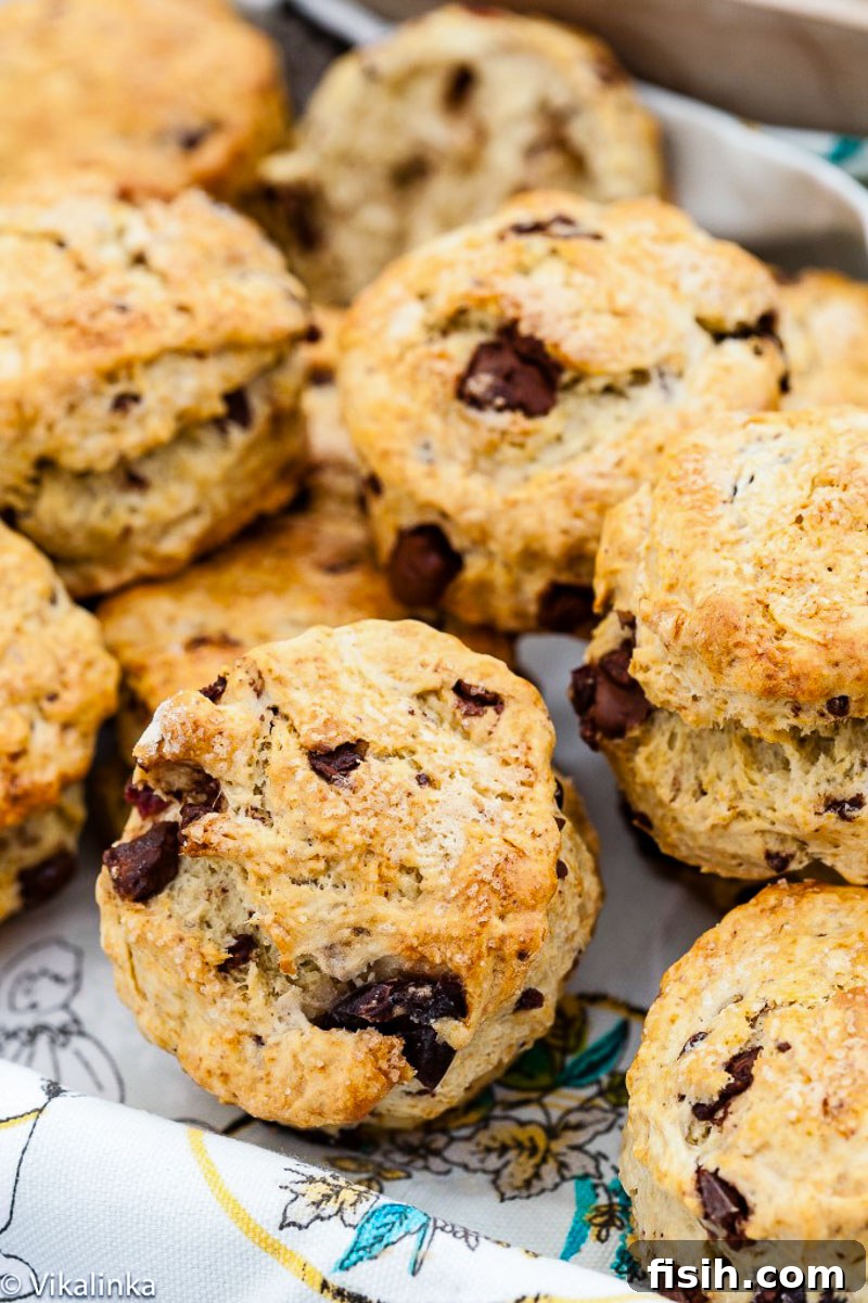 Close-up of fluffy chocolate chip scones on a teal linen towel, inviting a moment of indulgence.