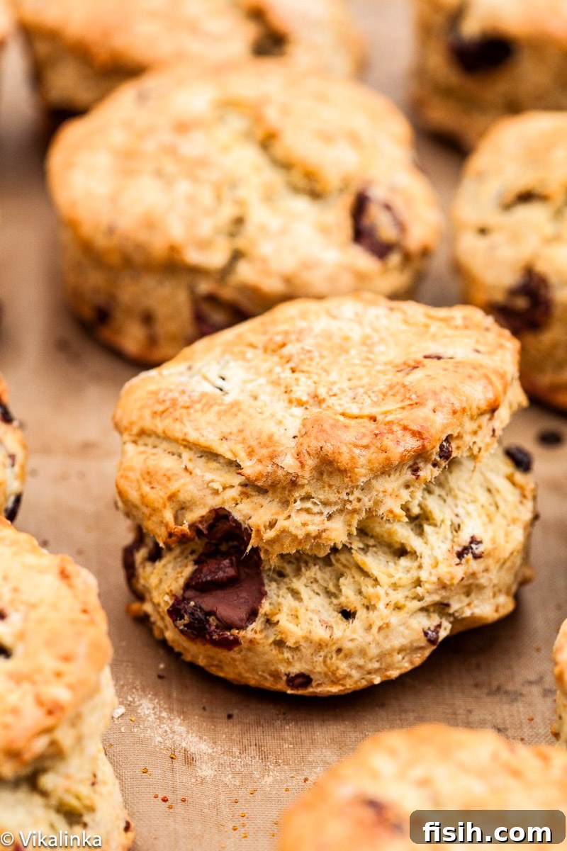 A single chocolate chunk scone on a rustic wooden board, showcasing its perfectly risen, golden-brown crust.