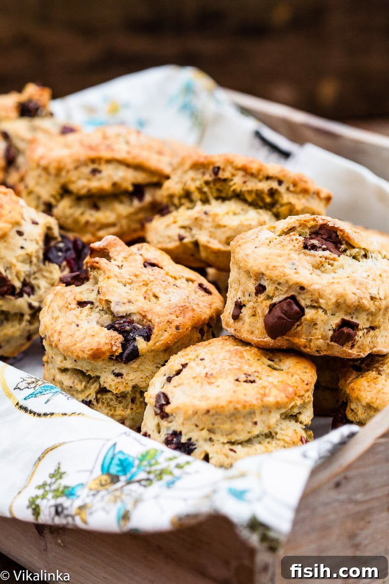 A charming collection of freshly baked scones nestled in a bread box on a kitchen towel, ready to be enjoyed.