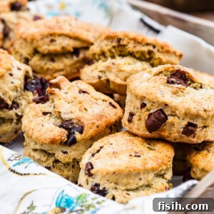 Freshly baked scones in a rustic bread box, garnished with a sprinkle of flour.