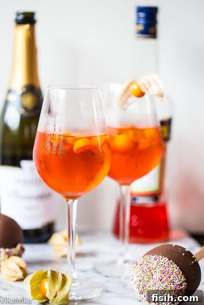 Golden Hour Refresher 2 Two glasses of vibrant orange Aperol Spritz cocktails, with blurred bottles in the background, set in a bright, inviting atmosphere.