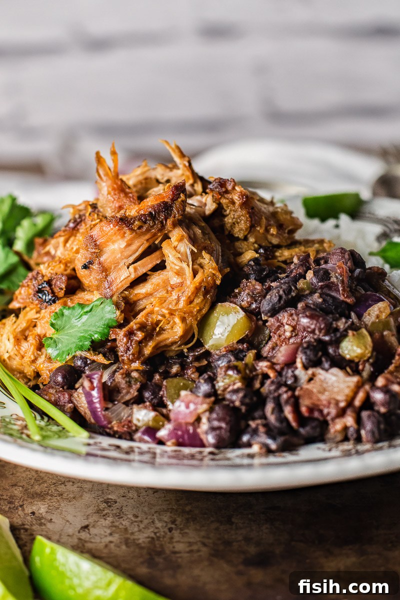A vibrant bowl of Cuban black beans, rich in color and texture, garnished with fresh cilantro, ready to be served.