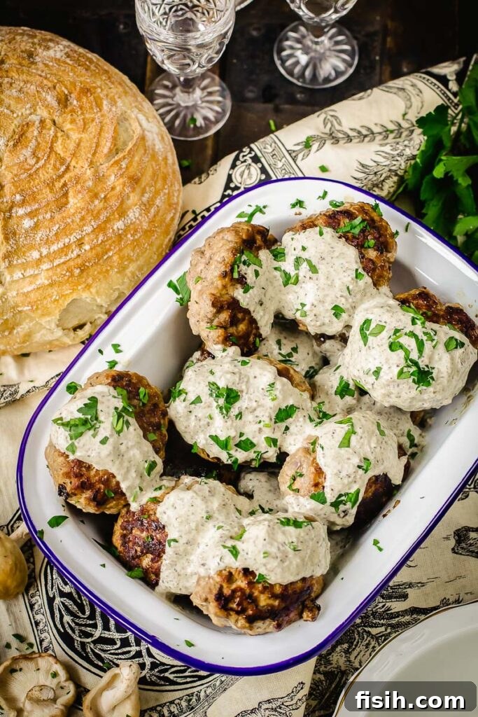 Savory Kotlety with Woodland Mushroom Sauce 2 meat patties with mushroom sauce poured over them and sprinkled with fresh herbs